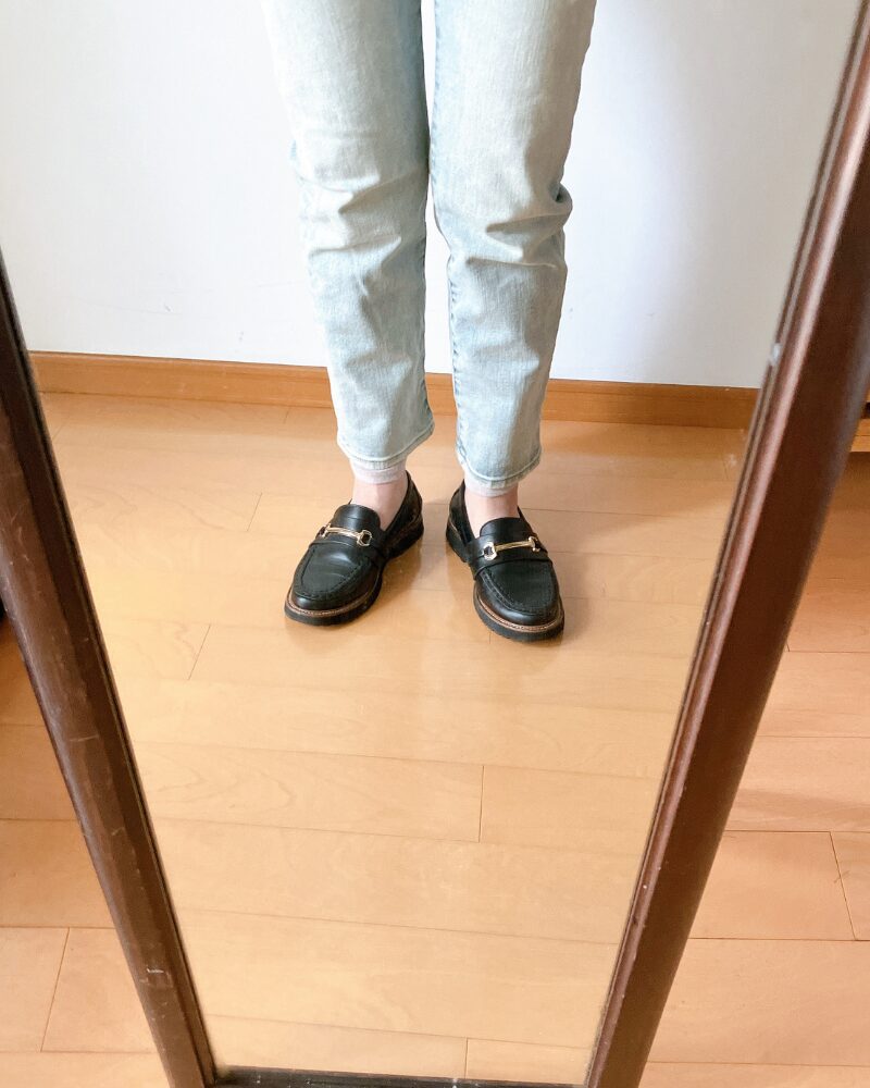 細身デニムの下にレッグウォーマーを着用している様子