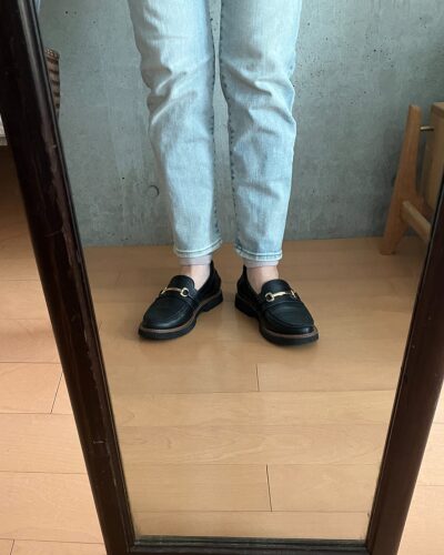 細身ジーンズの下にレッグウォーマーを着用して、素足にローファーを履いた様子（正面）