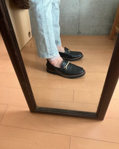 細身ジーンズの下にレッグウォーマーを着用して、素足にローファーを履いた様子（横から）