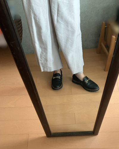 白いワイドパンツの下にレッグウォーマーを着用して、素足にローファーを履いた様子（正面）
