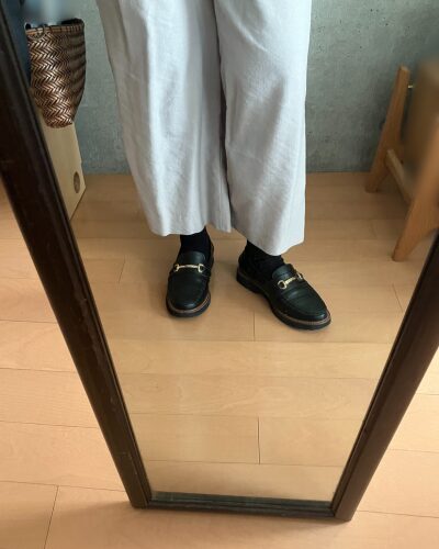 白いワイドパンツの下にレッグウォーマーと靴下を着用して、ローファーを履いた様子（正面）