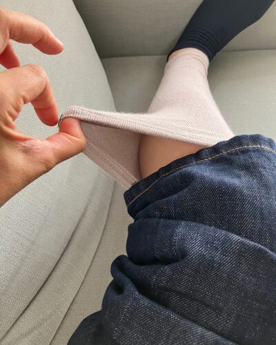 着用したレッグウォーマーを引っ張って薄さを見せている様子