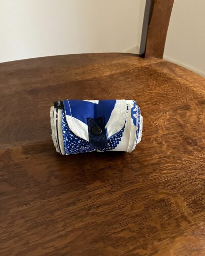 マーナのエコバッグ「シュパット」の両端を引っ張って、くるくる丸めて収納できる状態にしたもの
