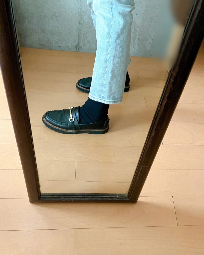 細身のデニムパンツの下にレッグウォーマーを着用し、その上から靴下を重ね履きして足元を整えた様子